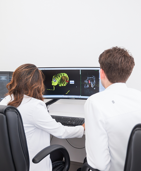 Two dentists looking at digital scans of a patient's teeth