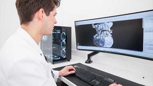 Dentist looking on a computer at scans of a patient's teeth