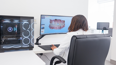 Dentist looking at photos of teeth on a computer