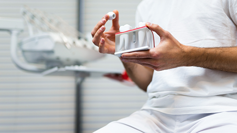 Dentist holding a model of a dental implant