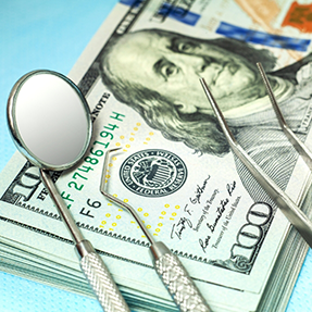 Dental instruments laying on top of money
