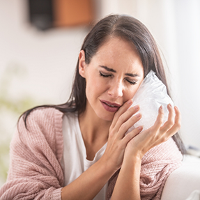 Woman holding an ice pack to her cheek