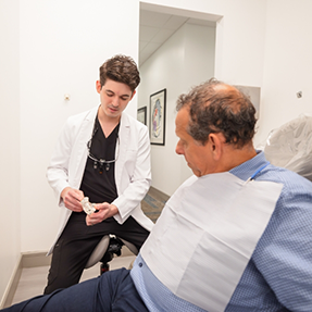 Older dental patient talking to his dentist