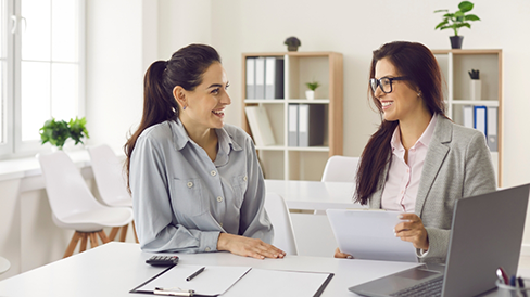 Two women at a table discussing finances