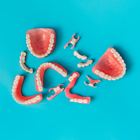 Several dentures on a flat blue surface