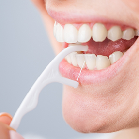 Close up of a person using a floss pick