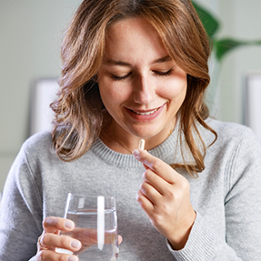 Woman taking a pill with water