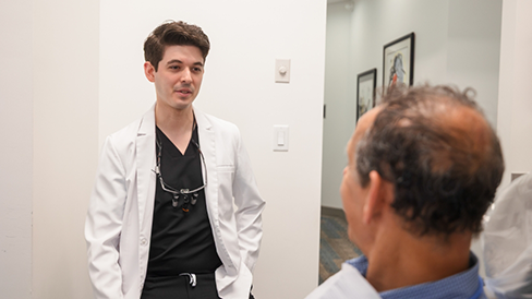 Man in the dental chair talking to his dentist