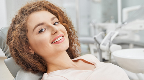 Smiling woman leaning back in the dental chair
