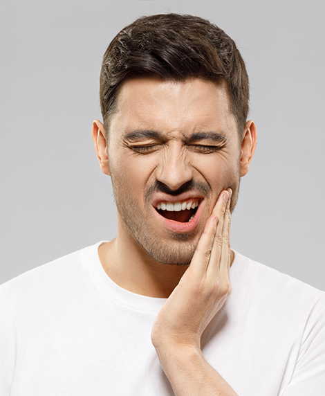 Man holding his jaw in pain before TMJ treatment in Coral Springs