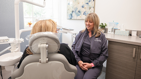 Coral Springs dental team member talking to a patient in the treatment chair