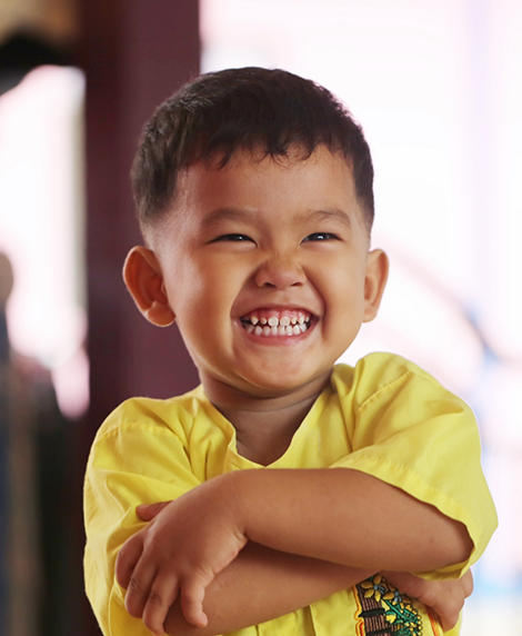 Young boy grinning after seeing a children's dentist in Coral Springs