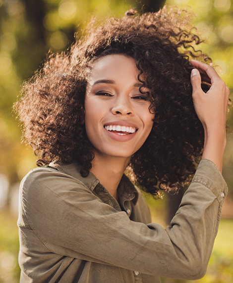 Woman smiling in the sun after cosmetic dentistry in Coral Springs