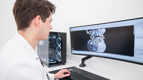 Dentist looking at scans of a patient's teeth on a computer