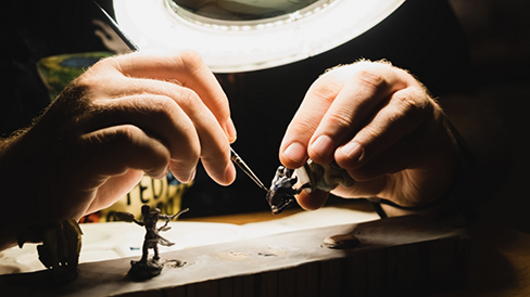 Close up of a person painting miniature figurines