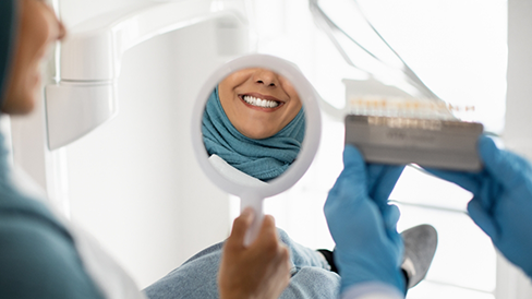 Dental patient admiring her smile in a mirror