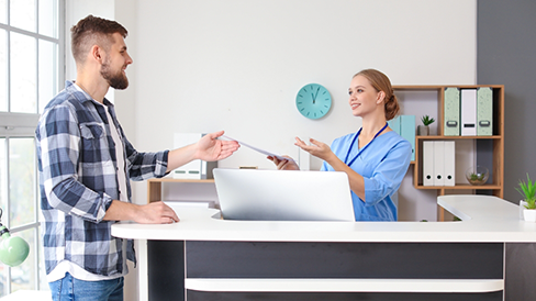 Dental team member handing a patient paperwork