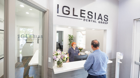 Man checking in at the front desk of Iglesias Dental Group