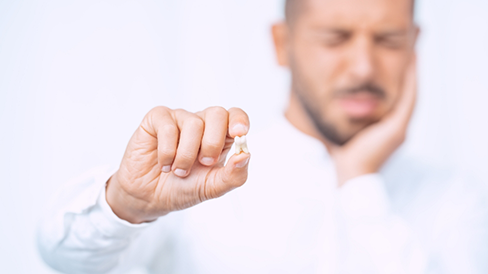 Man holding his extracted tooth